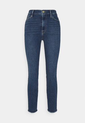 Tummansinisiä vyötäröltä korkeita farkkuja, jotka on valmistettu denimistä, slim fit -mallilla ja käänteellä. Sisältää etutaskut ja klassisen napitusclosure.