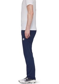 Navyblauwe sportbroek met een gladde textuur, slim fit en subtiele logo-details. Gecombineerd met een wit T-shirt en sportschoenen.