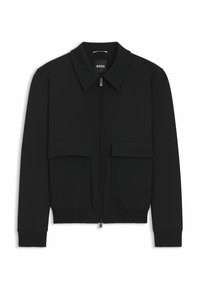 Veste bomber noire avec col, fermeture éclair à l'avant et deux grandes poches à rabat. Dotée de poignets et d'un bas côtelés, fabriquée en tissu texturé.