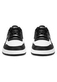 Czarno-białe niskie trampki z gładką skórzaną cholewką, perforowanym noskiem, płaskimi sznurowadłami i gumową podeszwą. Logo umieszczone na języku.