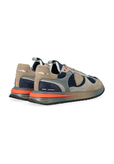 Una coppia di sneakers beige, blu navy e grigie con una combinazione di suede e mesh, striscia arancione sulla suola e branding "Olympique" sulle linguette del tallone.