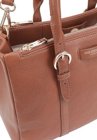 Bruine leren handtas met een gestructureerde afwerking, bovenhandvatten, twee ritsen en accenten in goudkleurig metaal. Voorzien van het merklabel aan de voorkant.