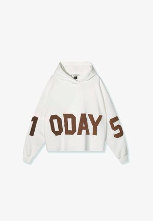 Witte cropped hoodie met bruine blokletters die "7 DAYS" aan de voorkant en op de mouwen spellen. Zachte stof en een relaxte pasvorm.
