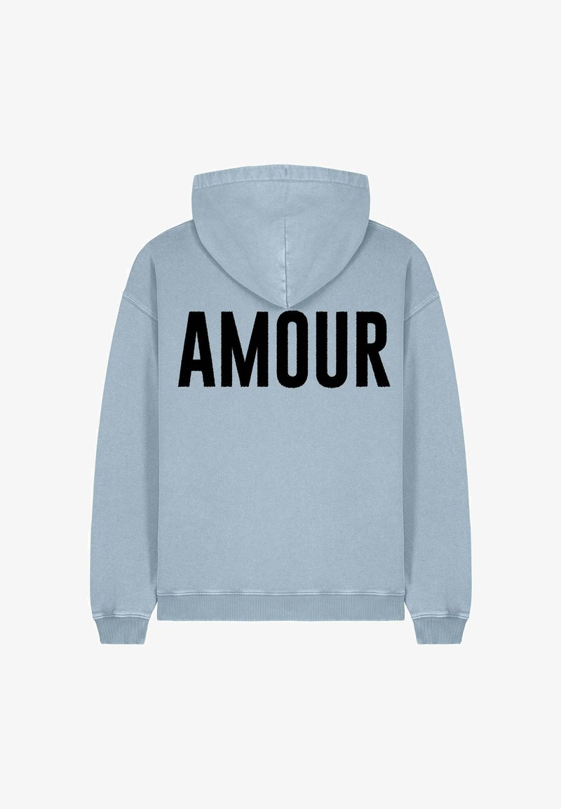Pale blue kapucnis pulóver, amelynek hátulján nagy fekete "AMOUR" felirat található. Puha anyagból készült, laza fazonú, és állítható kapucnival rendelkezik.