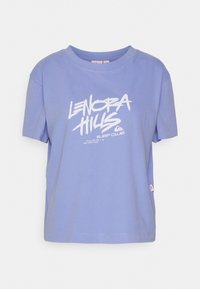 Camiseta de algodón de color morado claro con mangas cortas, cuello redondo y texto gráfico en blanco "LENORA HILLS SURF CLUB" en la parte delantera. Etiqueta de logo pequeña en la parte inferior.