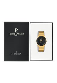Reloj de pulsera dorado con un dial negro, marcadores de horas minimalistas y una correa de metal dorada. Presentado en una caja negra con un interior blanco.