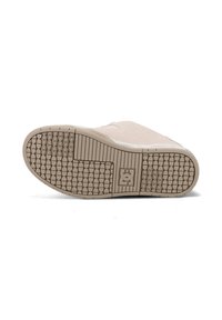 Beige shoe sole with a textured rubber pattern, featuring a flat design and prominent logo in the center. Smooth upper suede surface.