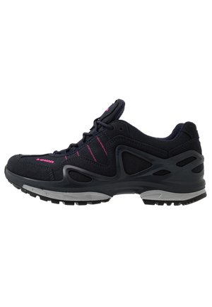 Black athletic shoe with pink accents, textured fabric upper, cushioned sole, and a supportive design featuring cutouts on the sides.