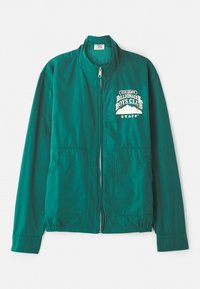 Grønn bomberjakke med full glidelås, stand-up krage, to sidelommer og et hvitt grafisk trykk på brystet. Glatt stofftekstur.