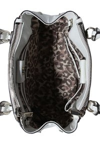 Biała skórzana torba na ramię z srebrnymi zamkami błyskawicznymi i wnętrzem z leopardzim nadrukiem, ukazująca przestronną komorę i boczne kieszenie.