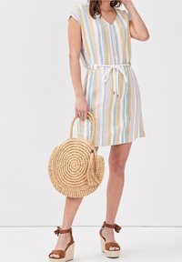 Robe rayée à manches courtes, décolleté en V, boutons et taille à cordon. Présente des couleurs bleue, jaune et rose. Les accessoires incluent un sac rond en osier.