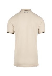 Beige poloshirt met een zwarte rand op de kraag en mouwen. Heeft een egale textuur en toont het logo op de achterkant.