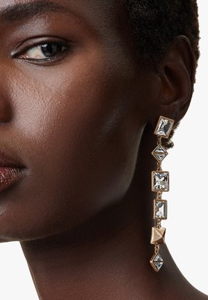 Gold-tone drop earrings featuring square and diamond-shaped clear crystals, arranged in a descending pattern with a polished finish.