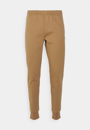 Pantalon de survêtement marron fuselé avec taille et poignets élastiques, fabriqué en tissu doux pour un port décontracté.