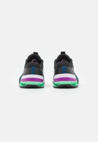 Black and teal athletic shoes with a textured mesh upper, reinforced heel, and colorful green, purple, and white accents on the sole.
