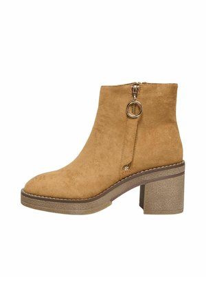 Bottine en suede marron clair avec un bout arrondi et une fermeture éclair sur le côté. Talon épais et texturé. Détails de couture minimaux.