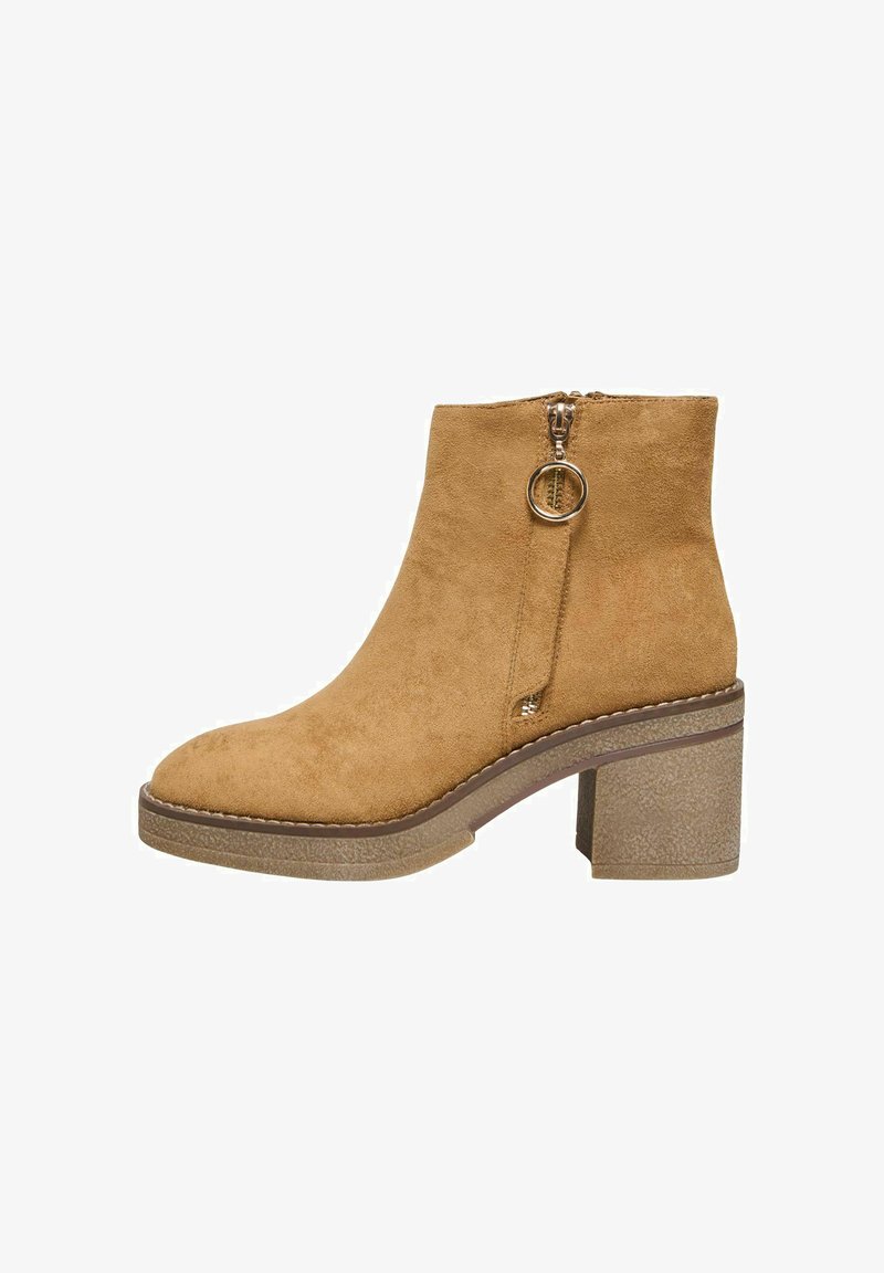 Botín de ante en marrón claro con puntera redondeada y un cierre de cremallera lateral. Tacón grueso con textura. Detalle de costura mínima.