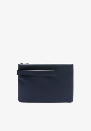 Pochette bracelet rectangulaire bleu marine avec fermeture éclair et petit logo crocodile embossé dans le coin inférieur droit.