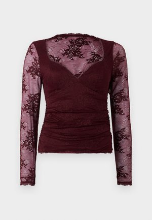Burgundijas garām piedurknēm tops ar mežģīņu audumu, kas rotāts ar ziedu rakstiem un krokām priekšā. Mīksta tekstūra ar viļņotu dekoltē un aprocēm.