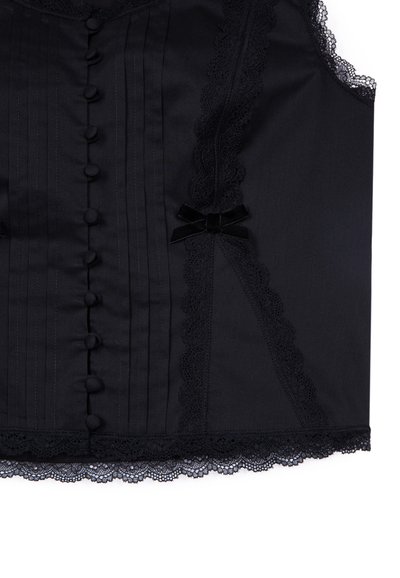 Corpiño negro con pliegues verticales, borde de encaje a lo largo de los bordes, lazos decorativos y botones forrados de tela en la parte delantera.