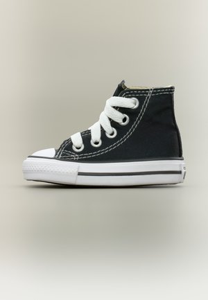Sneaker alta in tela nera con lacci bianchi, punta in gomma bianca e suola bianca con striscia nera, mostrata di profilo.