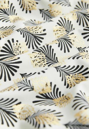 Tessuto bianco con un motivo dettagliato di foglie di palma nere e dorate. La superficie appare liscia e lucida con disegni intricati.