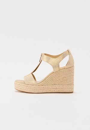 Sandalia cuña beige con plataforma de paja trenzada, puntera abierta, diseño de correa en T y cierre de cremallera en el tobillo.
