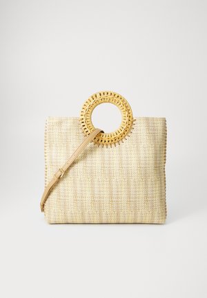Woven beige handbag with a round natural rattan handle. Features a structured shape and adjustable leather strap. Textured surface with stitching detail.