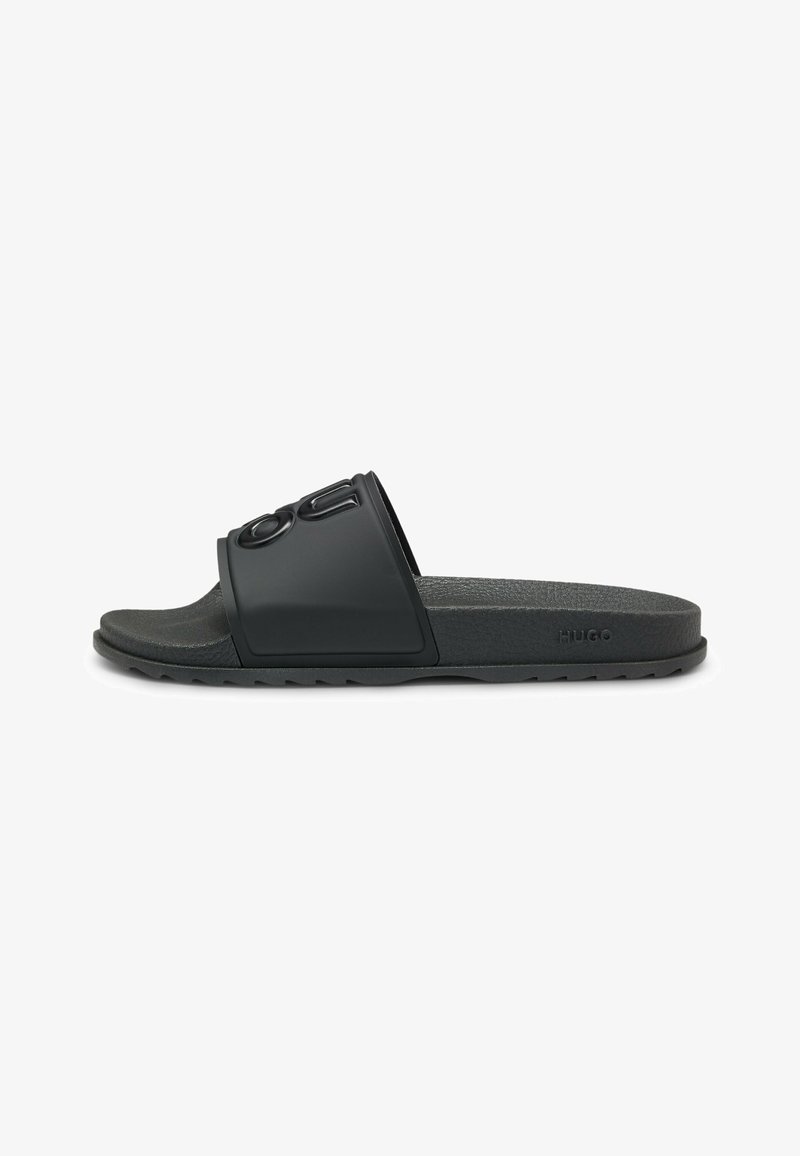 Black rubber slide sandal with a wide strap featuring embossed logo, textured footbed, and textured sole for grip.