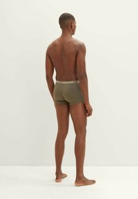 Olive green boxer shorts with a branded elastic waistband. View from the back, showcasing a close-fitting design and smooth texture.