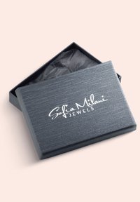 Sort tekstureret smykkeboks med et åbent låg, der har "Sofia Milani JEWELS" trykt i hvidt på toppen. Indvendigt beklædt med sort stof.