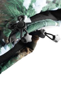 Bolsa plegable con un patrón de camuflaje en verde y marrón, que presenta un cordón negro y un forro interior acolchado y texturizado.