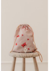 Pink snørebåndstaske lavet af blødt materiale med røde jordbær og sommerfugle. Fremhævet med en tan snørebånd og et diamantlogo-mærke.