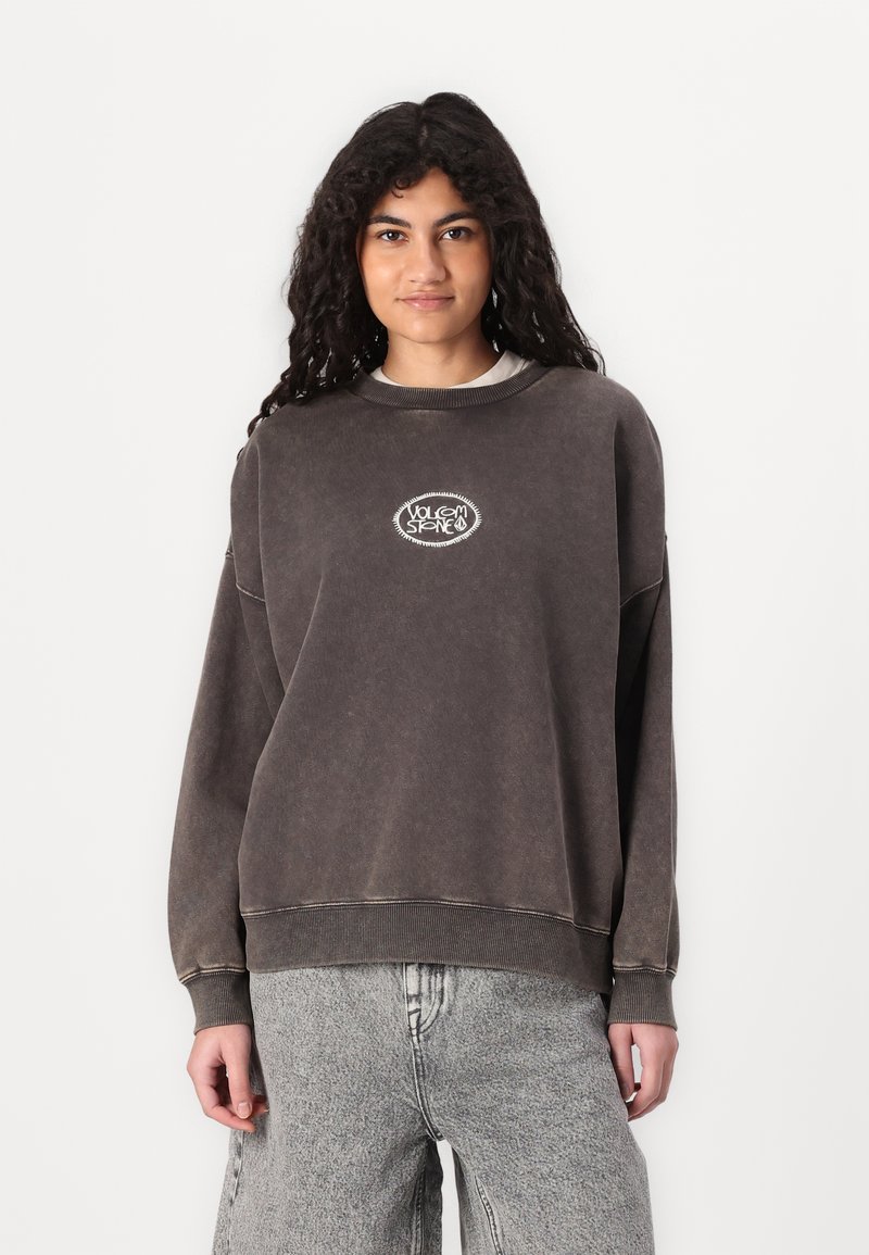 Oversized charcoal sweatshirt made of soft material featuring a round graphic logo in white, ribbed neckline, and cuffs.