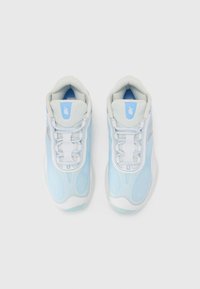 Ljusblåa träningsskor med en strukturerad ovandel, vita detaljer och snörningsdesign. Har en vadderad krage och logotypdetalj på tungan.