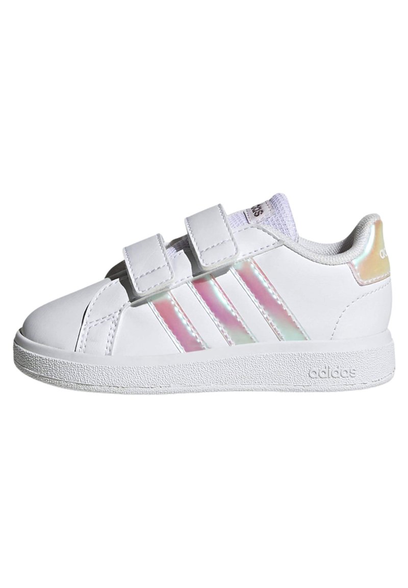 Biele tenisky s dvoma suchými zipsami, lesklými iridescentnými pruhmi, zaoblenou špičkou a textúrovanou gumovou podrážkou. Logo zobrazen�é na päte.