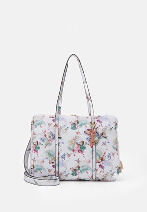 Witte handtas met kleurrijke bloemen- en vogelpatronen, dubbele handgrepen, afneembare schouderriem en een decoratieve vlinder sleutelhanger.