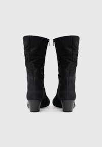 Knee-high black suede boots with a slim heel, featuring side zippers and a smooth texture. Plain design with no visible patterns or accents.