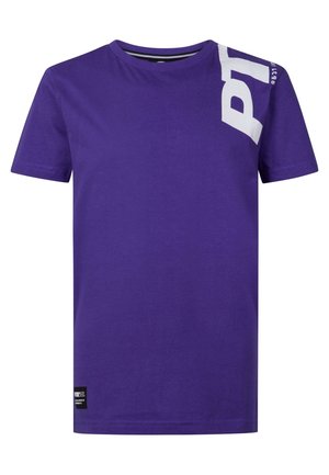 T-shirt violet à manches courtes avec texte blanc « PY » sur l'épaule gauche en haut et une petite étiquette noire près de l'ourlet inférieur.
