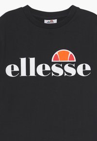 Juodas medvilninis marškinėliai su dideliu baltu "ellesse" logotipu, virš teksto esantis oranžinis ir geltonas lankas. Apvalaus iškirpimo dizainas.