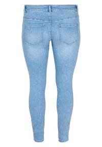 Jean skinny bleu clair vu de dos avec deux poches arrière, passants pour ceinture et taille ajustée.
