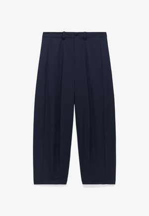 Pantalons ample bleu marine, fabriqués dans un tissu lisse, avec des plis avant, passants de ceinture et deux poches latérales. Design ajusté.