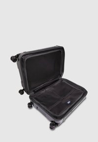 Valigia nera con guscio rigido, quattro ruote e un interno spazioso con tasche in rete e cerniere per l'organizzazione.