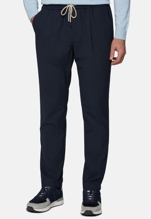 Marineblauwe broek met een ruime pasvorm, elastische tailleband en trekkoord. Voorzien van zijzakken en een soepele stofstructuur.