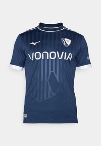 Camiseta de fútbol azul marino con rayas verticales, acentos blancos y logotipo. Hecha de una tela con una textura suave y diseño de cuello redondo.