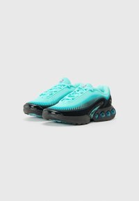 Scarpe da ginnastica turchesi con tomaia in rete, dettagli neri e una suola spessa con pod di ammortizzazione blu. Progettate per il comfort e le prestazioni.