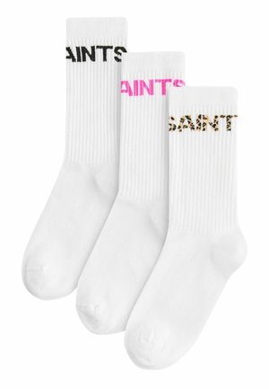 Drei Paar weiße Socken mit geripptem Muster; ein Paar hat schwarze Schriftzüge, ein anderes pinke und das letzte hat ein Leopardenmuster.