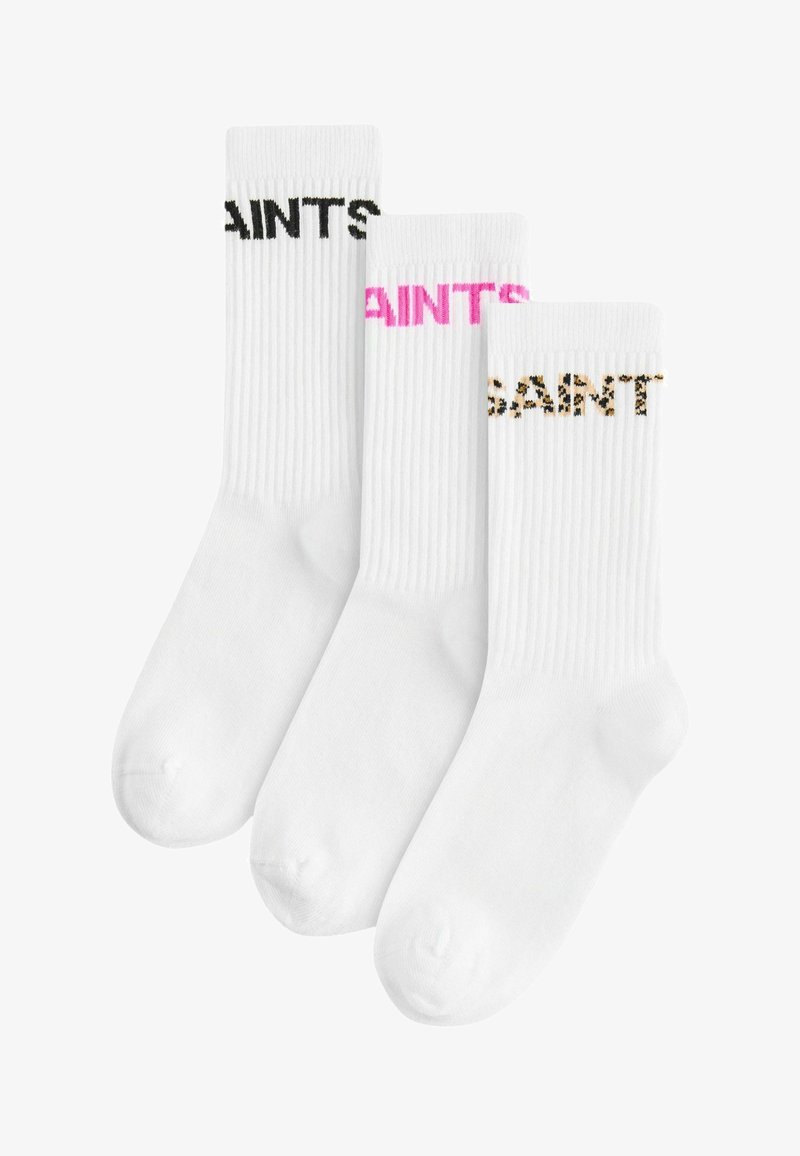 Trīs pāri baltu zeķu ar ribotu tekstūru; viens pāris ar melnu uzrakstu, cits ar rozā, un pēdējais ar leopardu rakstu.