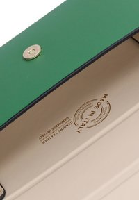 Portafoglio in pelle verde con chiusura a scatto dorata. L'interno presenta una fodera beige e le scritte "FABBRICATO IN ITALIA" e "PELLE REALE".