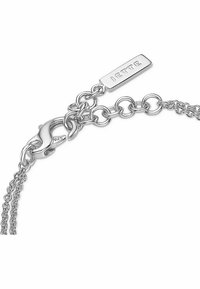 Bracciale in argento con maglie ovali, chiusura a moschettone e etichetta rettangolare incisa con la scritta "JETTE". Texture liscia in tutto il bracciale.